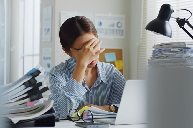 BUSY-1024x682 A tensed woman with hands on her head in her desk