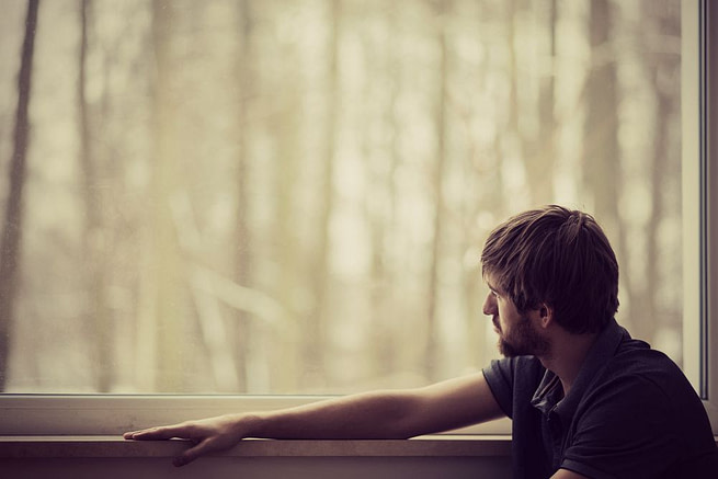 When-Someone-You-Love-Has-an-Addiction1 A alone man looking outside sitting in and looks upset