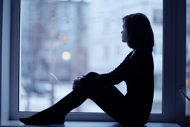 1557734268844 A lonely woman sitting in a dark room