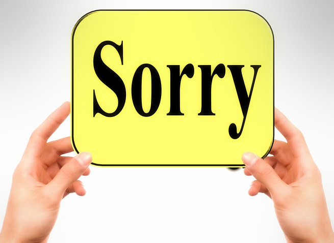 1520164244782 Hands holding a placard saying sorry