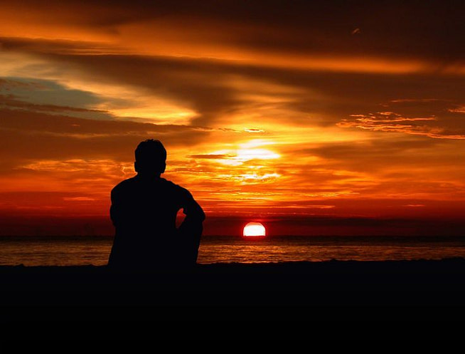 15539ad033a5c2b926b48290cdff5bb6 A man sitting on a sea beach in sunset