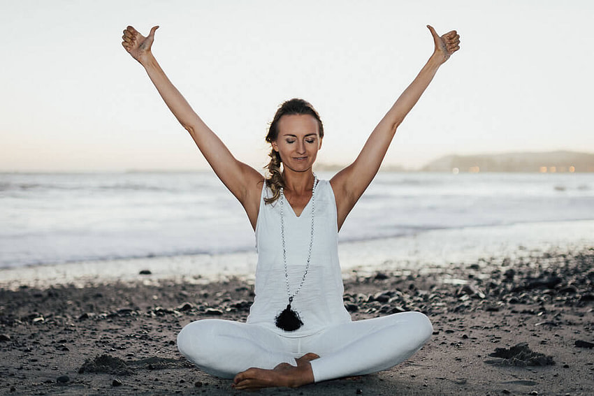 A woman at Yoga Pose on the sea shore
